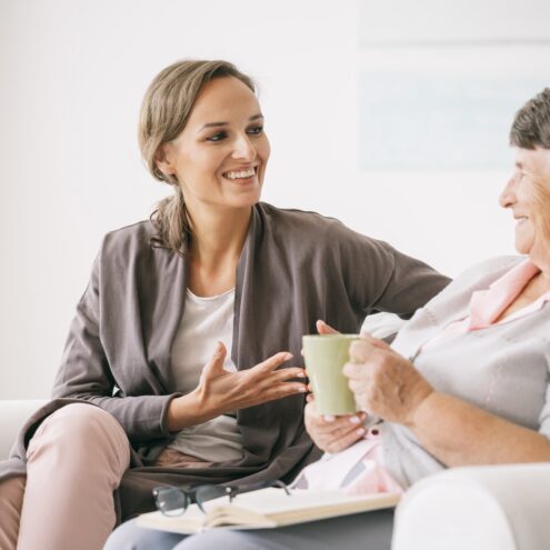 A young happy woman talking with her older mother at home